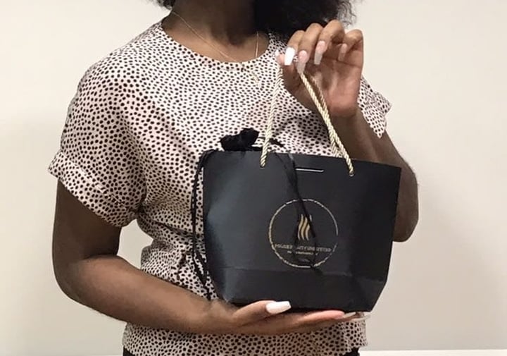 A woman holding a black shopping bag.