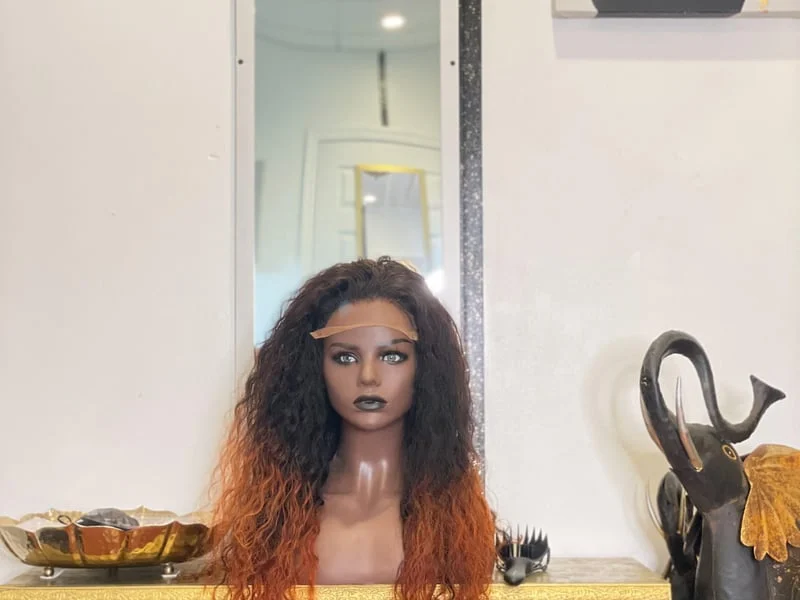 A mannequin with a wig and orange hair.