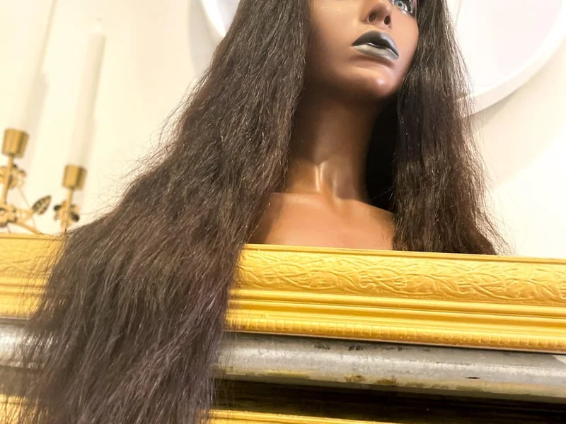 A mannequin with long black hair on top of a mannequin.