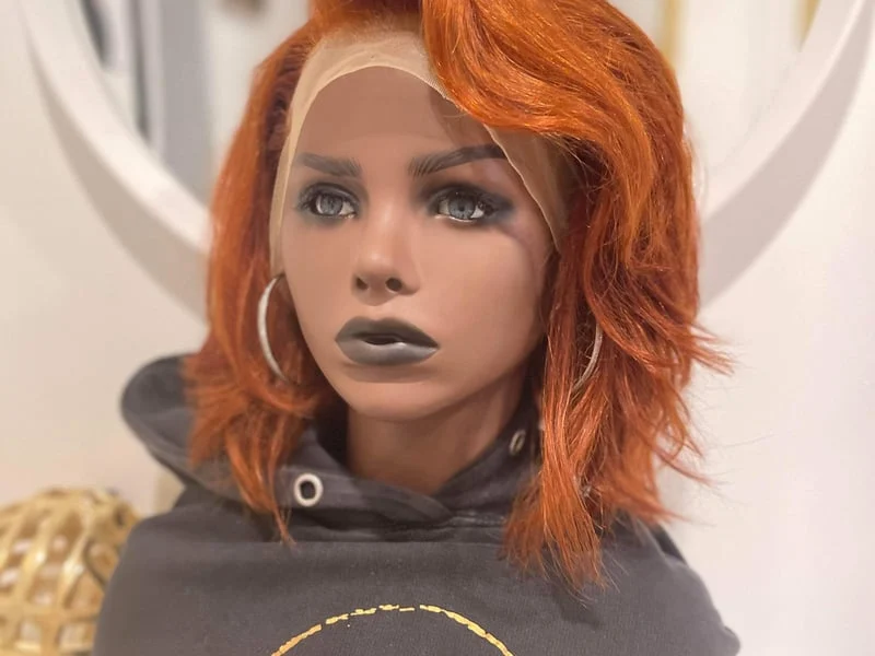A mannequin with orange hair and a hoodie.