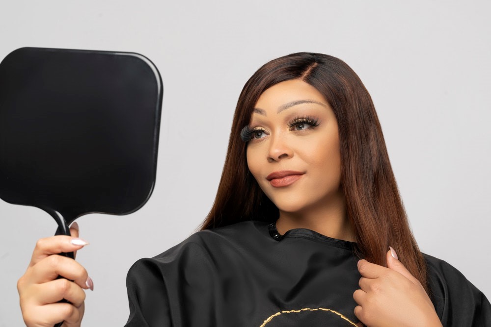 A woman is holding a mirror in front of a mirror.